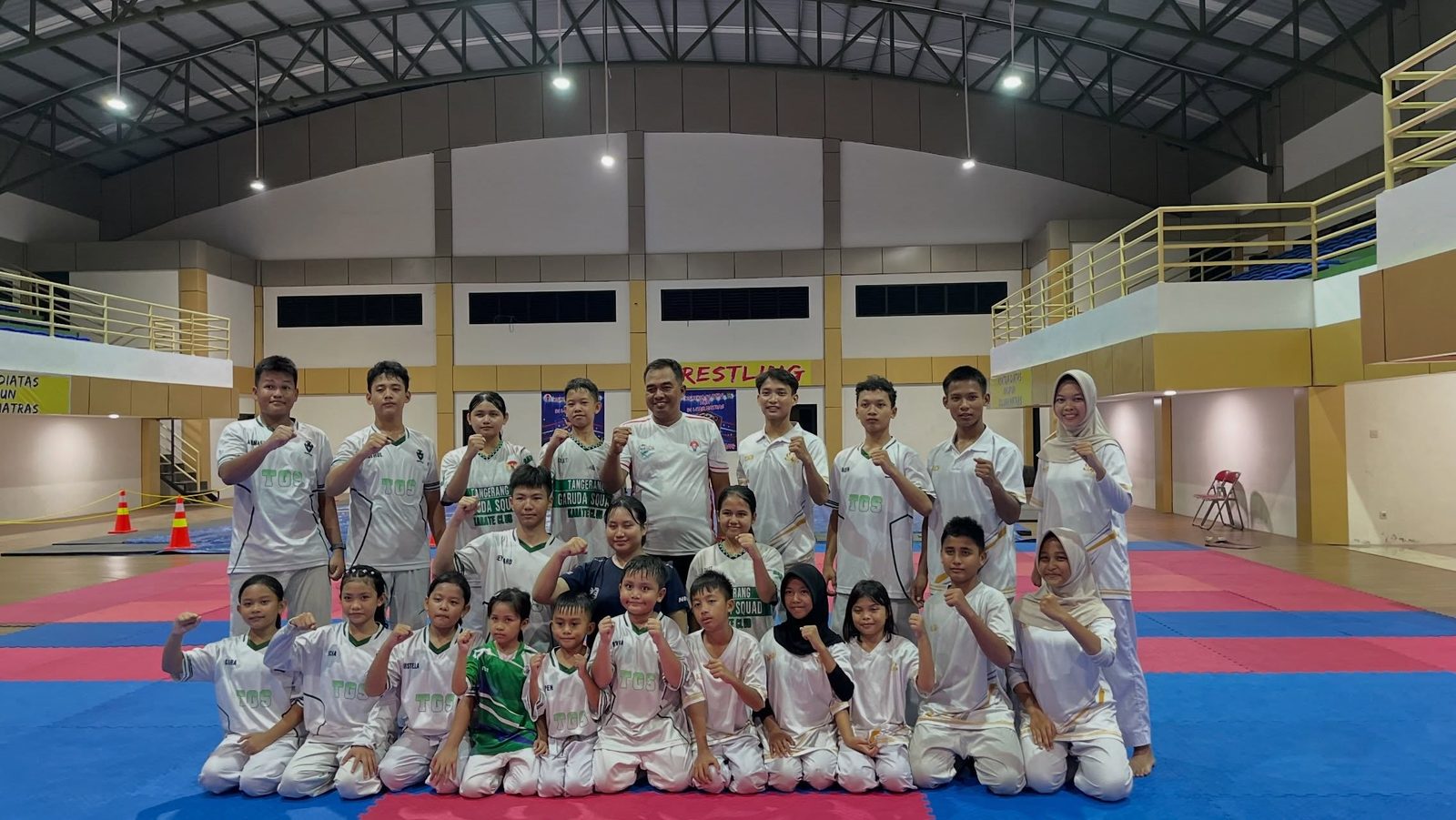 Atlet dan pelatih Tangerang Garuda Squad berfoto bersama di atas matras latihan di dalam gedung olahraga